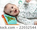 Happy infant lying in his bed with toys 22032544