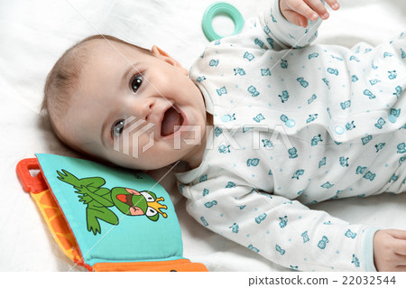 Happy infant lying in his bed with toys Happy infant lying in his bed with toys 22032544