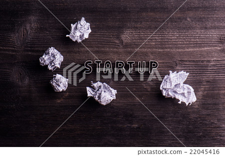 Desk with start up sign and crumpled paper balls Desk with start up sign and crumpled paper balls 22045416