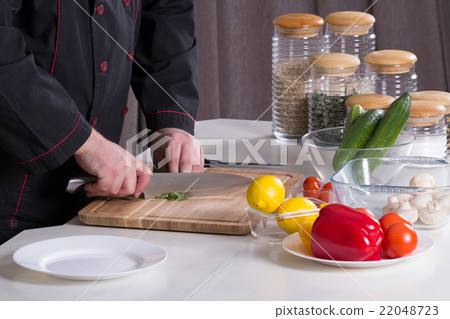 The chef cuts the greens 22048723
