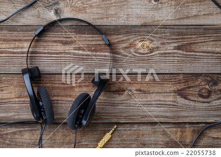Headphones over wooden table. 22055738