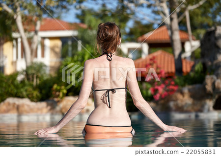 Woman relaxing in a swimming pool Woman relaxing in a swimming pool 22055831
