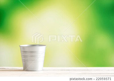 Metal bucket on a wooden desk 22059371
