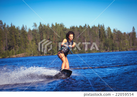 Woman study wakeboarding on a lake Woman study wakeboarding on a lake 22059554