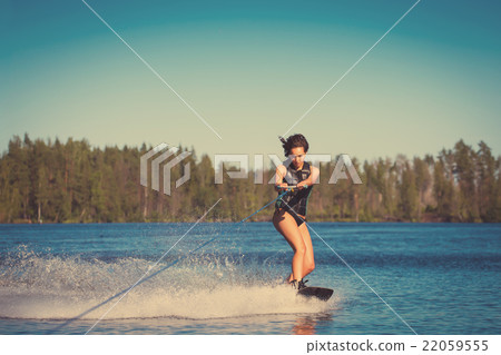 Young woman study riding wakeboarding on a lake Young woman study riding wakeboarding on a lake 22059555