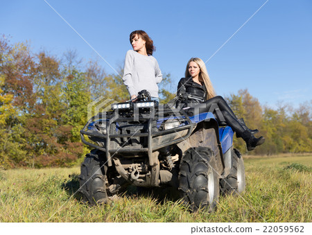 Two elegant women riding extreme quadrocycle ATV 22059562
