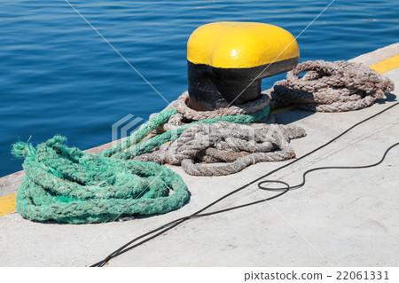 Yellow mooring bollard and nautical ropes Yellow mooring bollard and nautical ropes 22061331