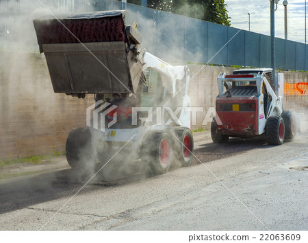 Two excavators perform milling of asphalt Two excavators perform milling of asphalt 22063609