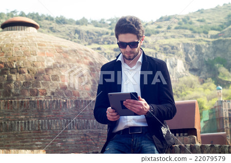 young bearded man outdoors with tablet young bearded man outdoors with tablet 22079579