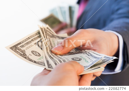 Business man giving bank notes to another person Business man giving bank notes to another person 22082774