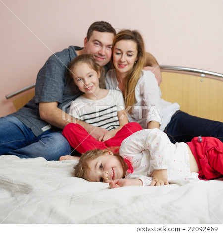 happy young family lying in bed happy young family lying in bed 22092469