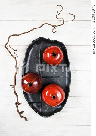 Many ceramic red pomegranates flat lay 22092973