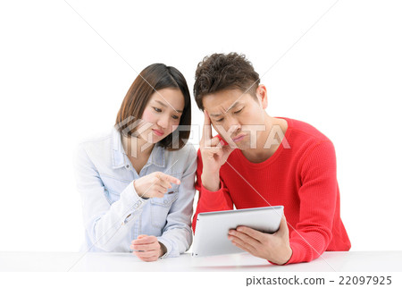 A white back image of a young couple watching the tablet on a white desk 22097925