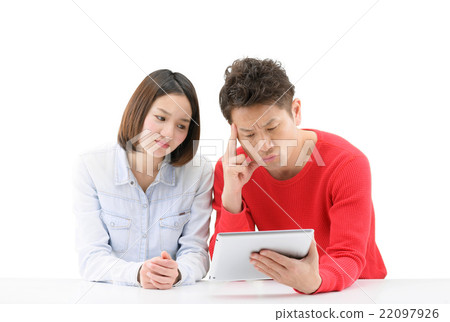 A white back image of a young couple watching the tablet on a white desk 22097926