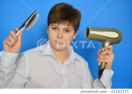 Boy teenager with comb and a hair dryer Boy teenager with comb and a hair dryer 22101275