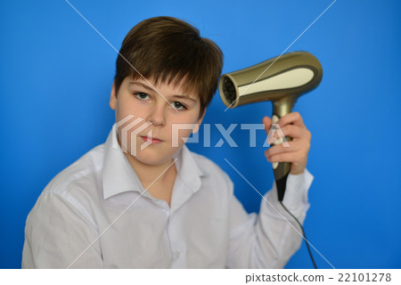 Boy teenager dries hair with hair dryer Boy teenager dries hair with hair dryer 22101278