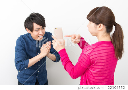 一個指著智能手機和懷疑的女人 22104552