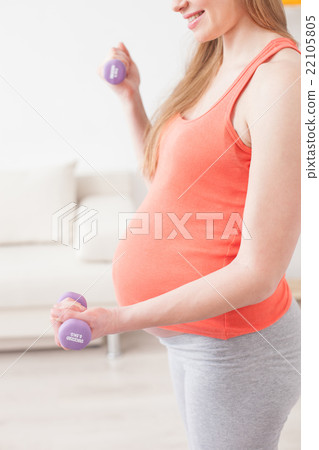 Cute pregnant woman is training with weights 22105805