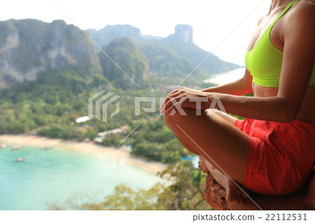 young fitness woman practice yoga at mountain peak cliff 22112531
