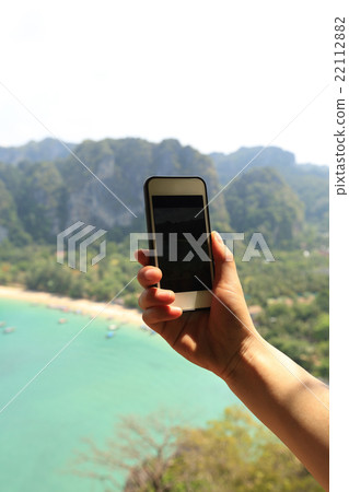 hand taking photo with smartphone at seaside hand taking photo with smartphone at seaside 22112882