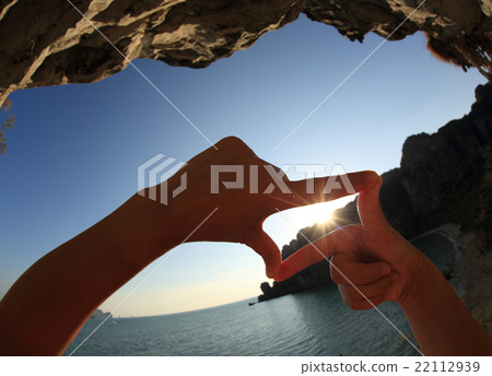 frame making of hands against seaside sunset frame making of hands against seaside sunset 22112939