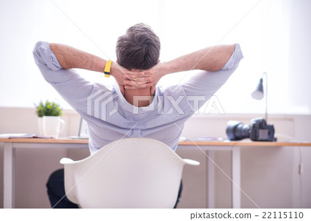 Pleasant man sitting at the table 22115110