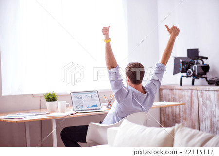 Pleasant man sitting at the table 22115112