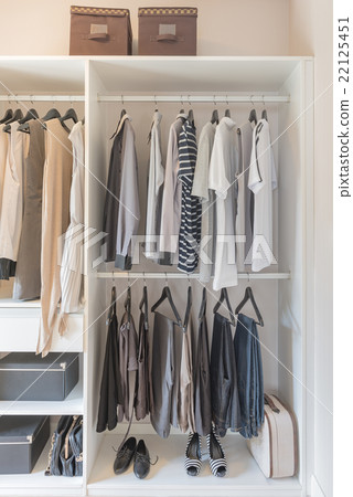 clothes hanging on rail in wooden closet at home 22125451