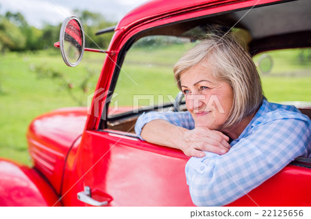 Close up of senior woman inside vintage pickup Close up of senior woman inside vintage pickup 22125656