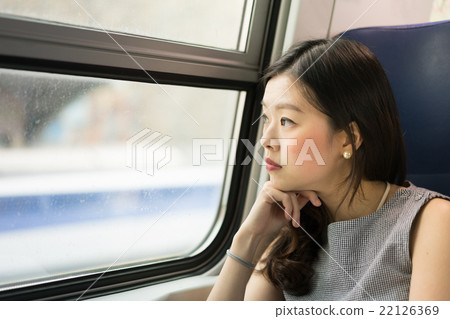 Asian woman looking out of train window,copy space Asian woman looking out of train window,copy space 22126369