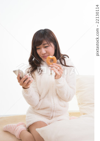 看智能手機的婦女，當吃多福餅時 22130114
