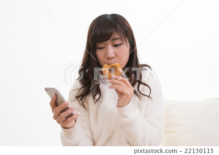 看智能手機的婦女，當吃多福餅時 22130115