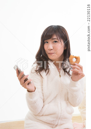 看智能手機的婦女，當吃多福餅時 22130116