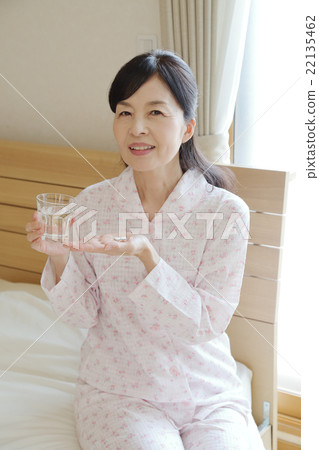 Women in pajamas who take medicine Women in pajamas who take medicine 22135462
