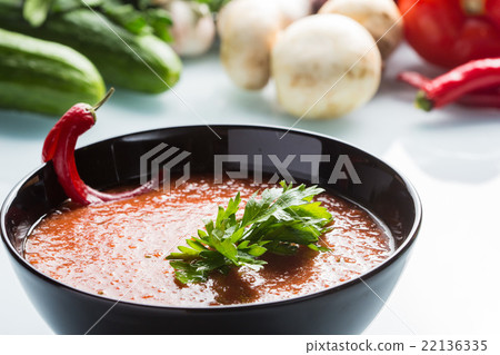 tomato soup in a black plate.  22136335