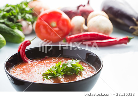 tomato soup in a black plate.  22136338