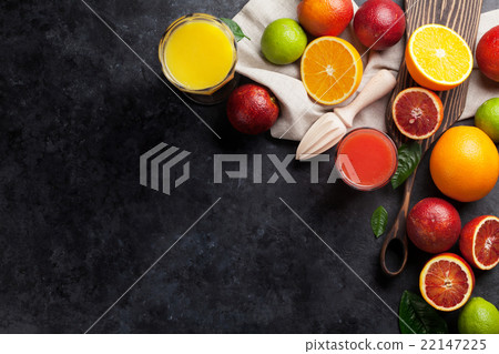 Fresh citruses and juice on dark stone 22147225