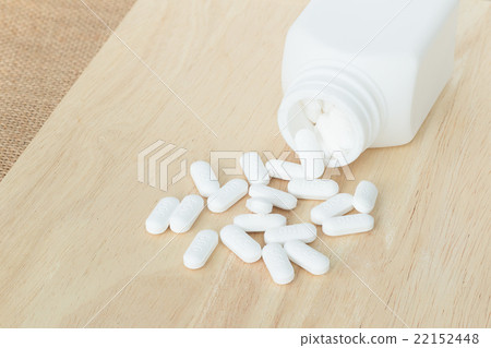 many white medicine on wood plate many white medicine on wood plate 22152448