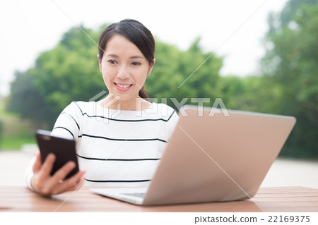 woman using laptop and smartphone woman using laptop and smartphone 22169375