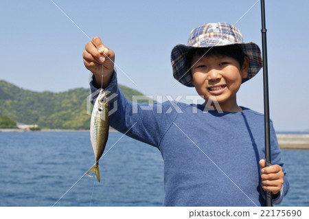 一個男孩高興地抓住了竹莢魚 22175690