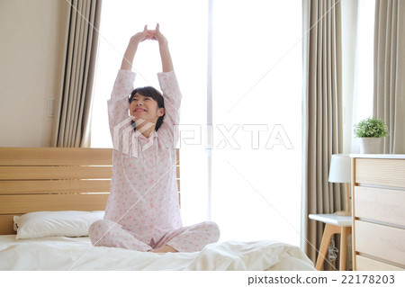 A woman stretching in bed 22178203