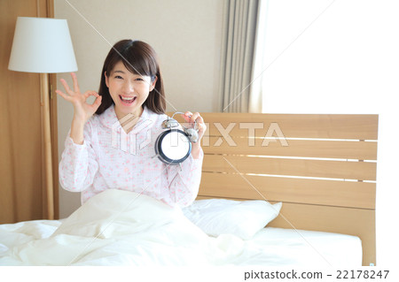 A woman with an alarm clock A woman with an alarm clock 22178247