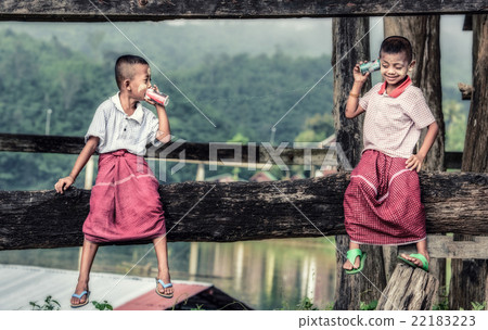 Asian boys talking on a can phone 22183223