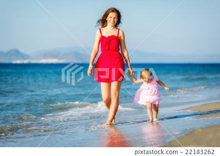 Mother and daughter walking on the beach 22183262