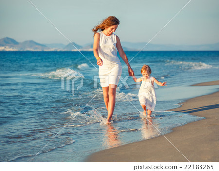 Mother and daughter walking on the beach Mother and daughter walking on the beach 22183265