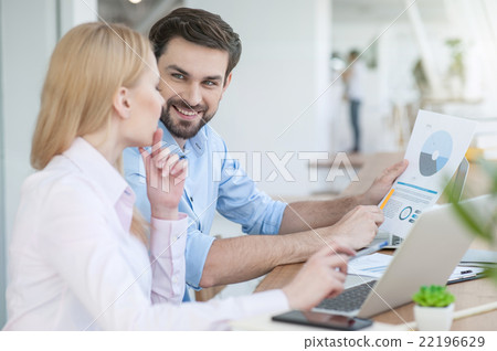 Cheerful two colleagues are working together Cheerful two colleagues are working together 22196629