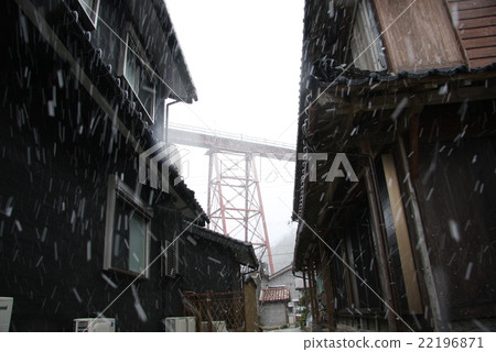 Look up the old-style iron bridge crossing the private house in the snow 22196871