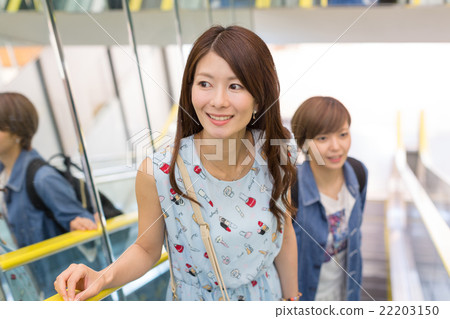 Two people riding escalators 22203150