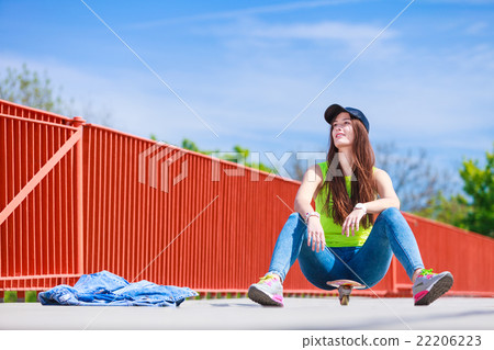 Teenage girl skater riding skateboard on street. 22206223