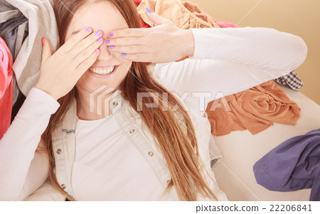 Happy woman lying on clothes covering eyes. 22206841